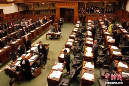 在南京大屠殺80周年之際，當(dāng)?shù)貢r間12月13日，加拿大安大略省省議會舉行南京大屠殺紀念活動。圖為安省議會議事大廳內(nèi)全體起立，為南京大屠殺數(shù)十萬死難者默哀。<a target='_blank' >中新社</a>記者 余瑞冬 攝