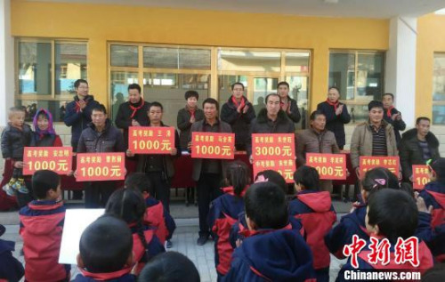 圖為吊坪村部分學(xué)生家長代子女領(lǐng)獎(jiǎng)助學(xué)金?！“瑧c龍 攝