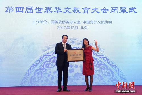 12月20日，第四屆世界華文教育大會在北京閉幕。圖為國務(wù)院僑務(wù)辦公室黨組書記、副主任許又聲(左)向法國小熊貓學(xué)校校長羅堅海外華文教育示范學(xué)校授牌。 <a target='_blank' >中新社</a>記者 崔楠 攝