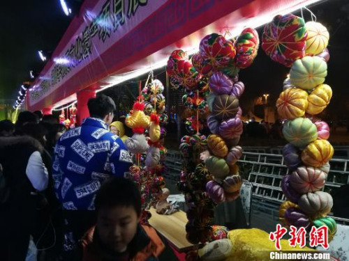 圖為民間工藝品展示吸引市民圍觀。　董飛 攝