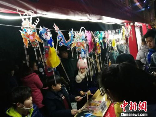 圖為捏糖人現(xiàn)場(chǎng)人頭攢動(dòng)?！《w 攝