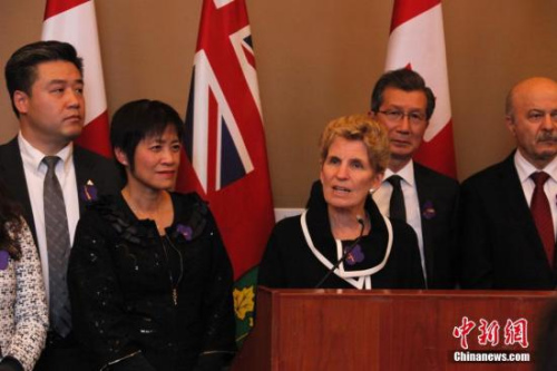 在南京大屠殺80周年之際，當?shù)貢r間2017年12月13日，加拿大安大略省省議會舉行南京大屠殺紀念活動。圖為安省省長韋恩(中)受邀出席紀念會，表示支持華人社區(qū)開展南京大屠殺紀念活動。這是該省省議會通過華人省議員黃素梅(左二)提出的“將每年12月13日設立為南京大屠殺紀念日”動議后，該省官方場合首次正式舉行南京大屠殺紀念活動。<a target='_blank' >中新社</a>記者 余瑞冬 攝