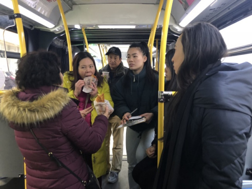 牛毓琳(右)為包厘街85號住戶準(zhǔn)備三明治，其辦公室工作人員幫助租戶登記。 (美國《世界日報》)