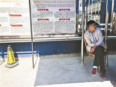 劉斌在派出所的遮陽棚下等待被綁架女友的消息。