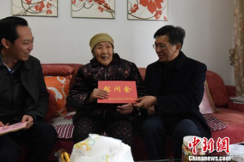 圖為重慶市人民政府外事僑務(wù)辦公室黨組書記、主任吳康明向南僑機(jī)工遺孀盈明英送上慰問金?！≈芤?攝