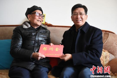 圖為重慶市人民政府外事僑務(wù)辦公室黨組書記、主任吳康明向南僑機工蔣印生送上慰問金?！≈芤?攝