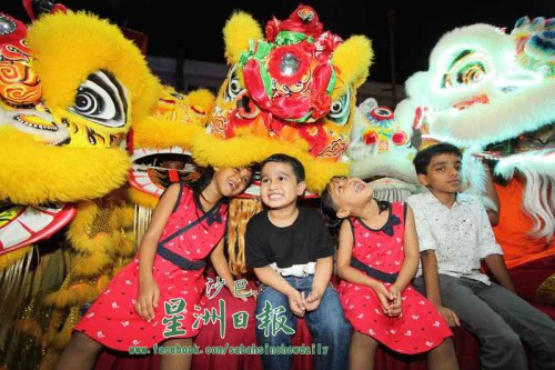 與醒獅近距離接觸，印裔孩童興奮不已。（馬來西亞《星洲日報》）