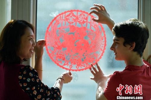 2月15日，中國傳統(tǒng)春節(jié)即將到來，在河北石家莊第42中學(xué)就讀的意大利留學(xué)生子軒，與他的美國、泰國好朋友們?cè)凇爸袊鴭寢尅惫鶑惣抑邪溩?、貼春花，感受中國傳統(tǒng)春節(jié)的韻味。 <a target='_blank' >中新社</a>記者 翟羽佳 攝 2月15日，中國傳統(tǒng)春節(jié)即將到來，在河北石家莊第42中學(xué)就讀的意大利留學(xué)生子軒，與他的美國、泰國好朋友們?cè)凇爸袊鴭寢尅惫鶑惣抑邪溩?、貼春花，感受中國傳統(tǒng)春節(jié)的韻味。 <a target='_blank' >中新社</a>記者 翟羽佳 攝