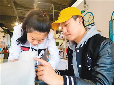 　　高士達(dá)(右一)覺得沒有家人的陪伴，在海外留學(xué)時(shí)心里始終少了一些溫暖。在家時(shí)，他希望自己可以多與家人相處，彌補(bǔ)在外留學(xué)的遺憾。圖為他和妹妹在一起逗小貓。 張馨予攝