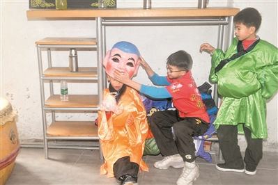 學習了一個上午的大頭佛表演，小學徒在一旁休息。