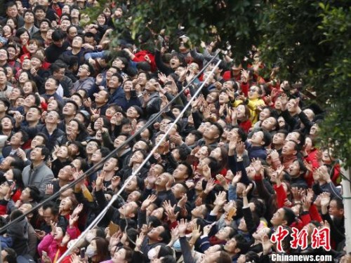 　現(xiàn)場(chǎng)人群高舉雙手，大聲呼喊，奮力接住“僮身”拋來(lái)的銅錢(qián)，以求平安、發(fā)財(cái)、好運(yùn)?！×謩俎?攝