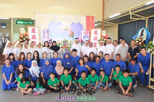 瑪西達(后排左7)和阿紹(后排右7)與子女們身穿孝服在靈堂前，依照華人習俗為華裔生父治喪。(馬來西亞《中國報》)