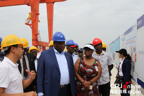 中國路橋肯尼亞辦事處總經(jīng)理李強(qiáng)(左一)向剛果(布)大型工程部長布亞(左二)介紹蒙內(nèi)鐵路蒙巴薩賴茨港鐵路貨運(yùn)站情況 攝影：王新俊
