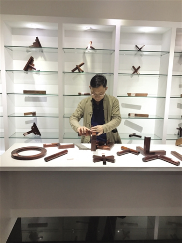 坐落在新會600多平方米的“魯班館”，首期陳列著87款的“榫卯結(jié)構(gòu)”，新會“魯班館”通過實物、圖紙等形式，展示中國傳統(tǒng)手工藝技術(shù)。圖為新會工匠盧貴星表演拆裝工藝。