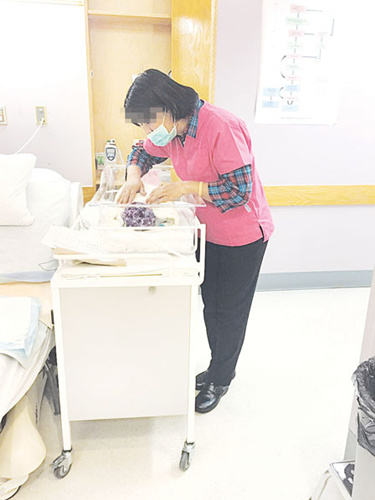 月子中心收到的查詢數(shù)量大增，圖為月嫂在醫(yī)院照顧初生嬰兒。(加拿大《明報》資料圖)