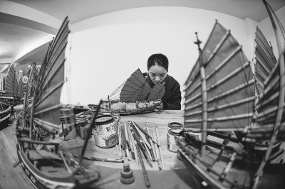  藝人在制作福船，微縮的船身里五臟俱全。