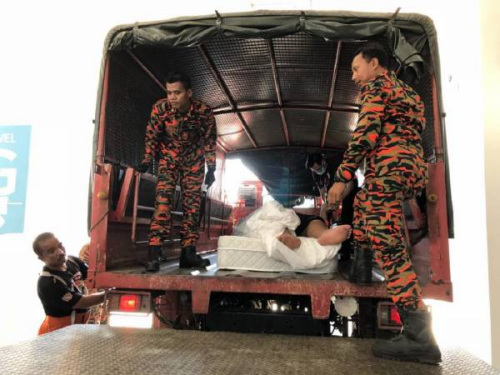 華裔男子被抬上卡車送往醫(yī)院。（馬來西亞《中國報(bào)》）