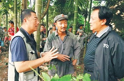 拍攝《天涯浴血》時(shí)，唐國(guó)強(qiáng)(右一)與制片人、演員溝通拍攝細(xì)節(jié)。 (受訪者供圖)