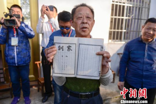 金橋村村民羅仲璜向海外華文媒體一行展示羅氏家訓。　楊華峰 攝