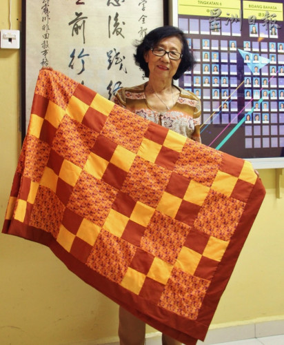 花紋較精巧的百家被更為耗時，一張得花上一兩天才能做成，而且縫制之前還得從巨型百家被分拆下來的料子中挑選花樣。（馬來西亞《星洲日報》圖片）