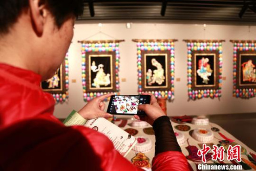 3月29日，青海省美術(shù)館正在展出“中國非物質(zhì)文化遺產(chǎn)傳承人群研修研習(xí)培訓(xùn)計劃”青海地區(qū)的豐碩成果，圖為參觀者給展出的堆繡成果拍照。　馬銘言 攝