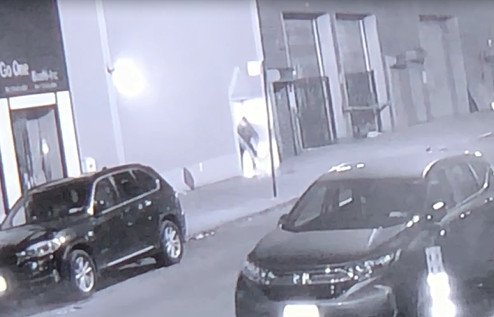 夜店內(nèi)有人出門拖地清理門口。