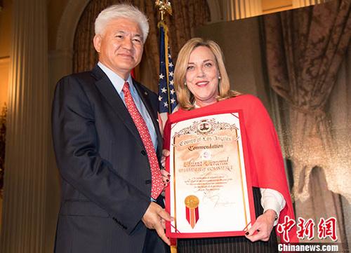 　資料圖：2月22日美國(guó)中國(guó)總商會(huì)2018年年會(huì)上，洛杉磯郡郡政委員凱瑟琳·巴格為美國(guó)中國(guó)總商會(huì)洛杉磯分會(huì)會(huì)長(zhǎng)張旭明(左)頒獎(jiǎng)。針對(duì)特朗普對(duì)中國(guó)加稅，張旭明表示，這劑“藥方”顯然是開錯(cuò)了。 <a target='_blank' >中新社</a>記者 張朔 攝