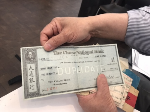 梁晉展示父親匯款回中國(guó)的支票。(記者牟蘭／翻拍)