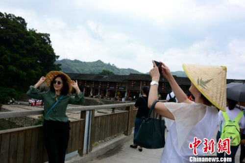 　南靖土樓云水謠景區(qū)吸引眾多游客駐足拍照。　張金川 攝
