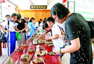  家長(zhǎng)與學(xué)生選購(gòu)義賣(mài)的陶藝作品 特約通訊員 王永平 攝影報(bào)道