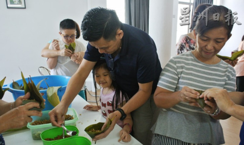 家長(zhǎng)帶著小朋友一起包粽子，享受假期的親子樂。（馬來西亞《星洲日?qǐng)?bào)》）