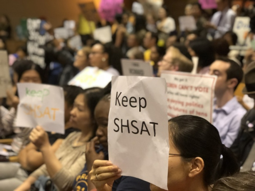 針對特殊高中改革，不少家長帶著抗議牌前往參加會議。(美國《世界日報》/黃伊奕攝)