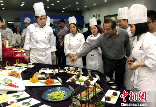  資料圖：老師點(diǎn)評(píng)學(xué)生淮揚(yáng)菜作品。　崔佳明 攝