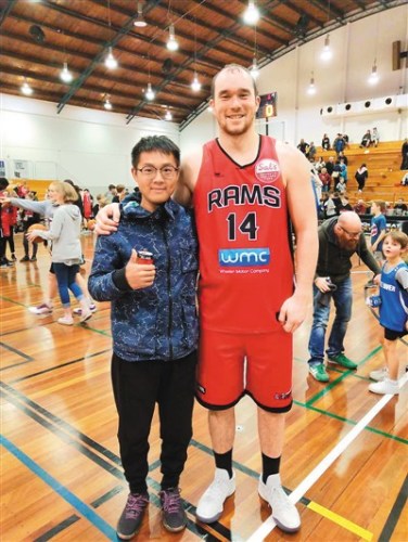 　圖為吳宇森在新西蘭球館觀看籃球賽時和球員合影留念。