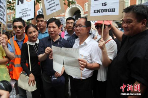 7月24日，倫敦市中心著名的唐人街中餐館、超市、商鋪等170多個(gè)華人商家集體罷市，上千華人沿街游行，抗議英國(guó)移民局粗暴執(zhí)法。這是倫敦華人社會(huì)歷史上最大規(guī)模的罷市游行。圖為倫敦華埠商會(huì)主席鄧柱廷（前左3）等僑領(lǐng)在展示致英國(guó)內(nèi)政部的申訴信函。 <a target='_blank' >中新社</a>記者 張平 攝