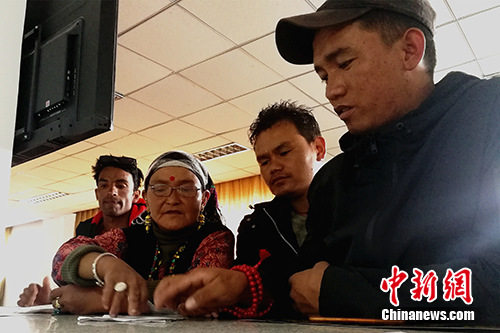 圖為今年57歲的尼泊爾商人贊達(dá)熱·瓦迪(左二)在阿里獅泉河海關(guān)普蘭工作點(diǎn)的業(yè)務(wù)大廳內(nèi)辦理通關(guān)手續(xù)。<a target='_blank' >中新社</a>記者 趙延 攝