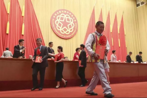 高德榮(前)手捧榮譽(yù)證書。<a target='_blank' >中新社</a>記者 盛佳鵬 攝