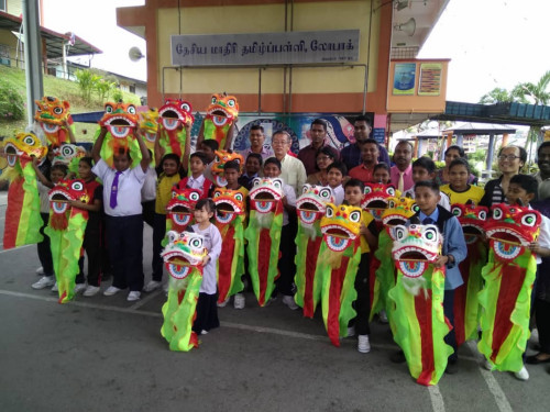 周世揚(yáng)（后排中）贈(zèng)送舞獅予羅白淡小，促進(jìn)文化交融。（馬來(lái)西亞《光華日?qǐng)?bào)》）