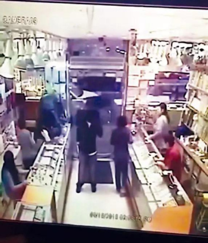 一名嫌犯鳴槍恐嚇，另一人爬進(jìn)柜臺搶走珠寶。視頻截圖