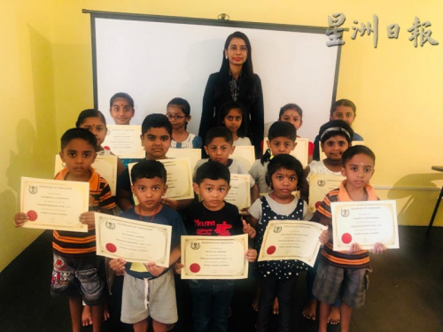 在完成了一個(gè)階段的學(xué)習(xí)后，孩童們開心地從普麗緹(后排中)手中接過“畢業(yè)證書”。(馬來西亞《星洲日?qǐng)?bào)》)