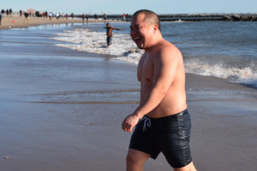 完成冬泳挑戰(zhàn)的林悅聰，滿臉開心走回岸邊。（美國《世界日報》/顏潔恩 攝）