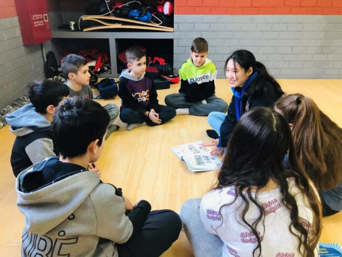 志愿者覃步宇和學(xué)生做游戲。(歐洲時報通訊員秦樂樂 攝)