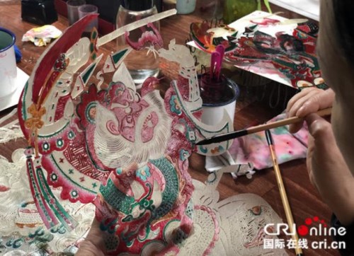 匠人給雕刻完成的皮影上色，手法細(xì)致而精準(zhǔn)，攝影：張捷