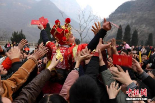 資料圖：“財(cái)神”向游客派發(fā)現(xiàn)金紅包。 王中舉 攝