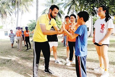 埃及大學(xué)生志愿者艾哈邁德與孩子們做游戲。 本報(bào)記者 袁宇 通訊員 楊一帆 攝