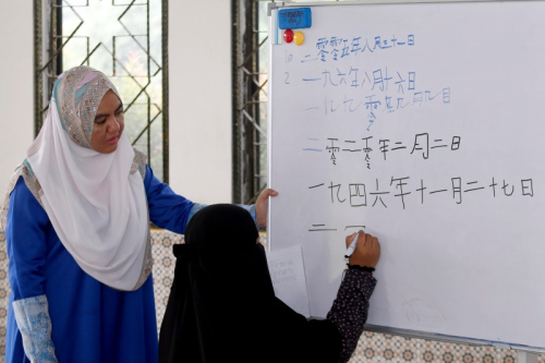 盧萊茵在課堂上教導學生用華文字寫出日期。(馬來西亞《星洲日報》/陳敬暉 攝)