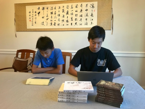 圖為楊瑞盟(右)用筆記本電腦編程，楊海盟用iPad讀標(biāo)了拼音的金庸電子書。(美國《世界日?qǐng)?bào)》記者王明心／攝影)