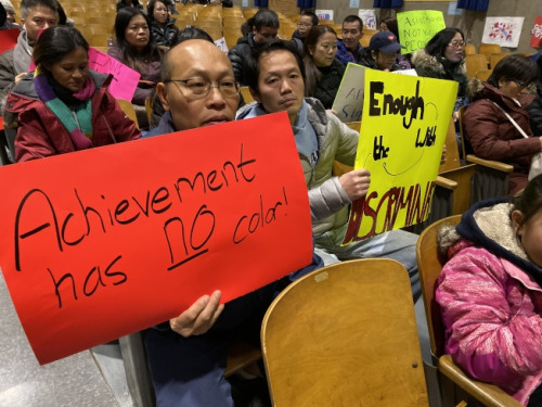 紐約上百名華裔家長(zhǎng)手舉抗議牌在會(huì)議現(xiàn)場(chǎng)。(美國(guó)《世界日?qǐng)?bào)》/黃伊奕 攝)