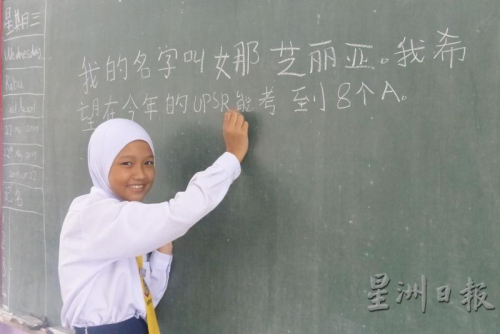 娜芝麗亞以工整的中文字體，在黑板上寫下自己的心愿。(來源：星洲日報)