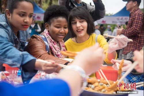 資料圖：廣西柳州舉行千米長(zhǎng)桌螺螄粉宴，幾名外國(guó)游客正在品嘗螺螄粉。王以照 攝